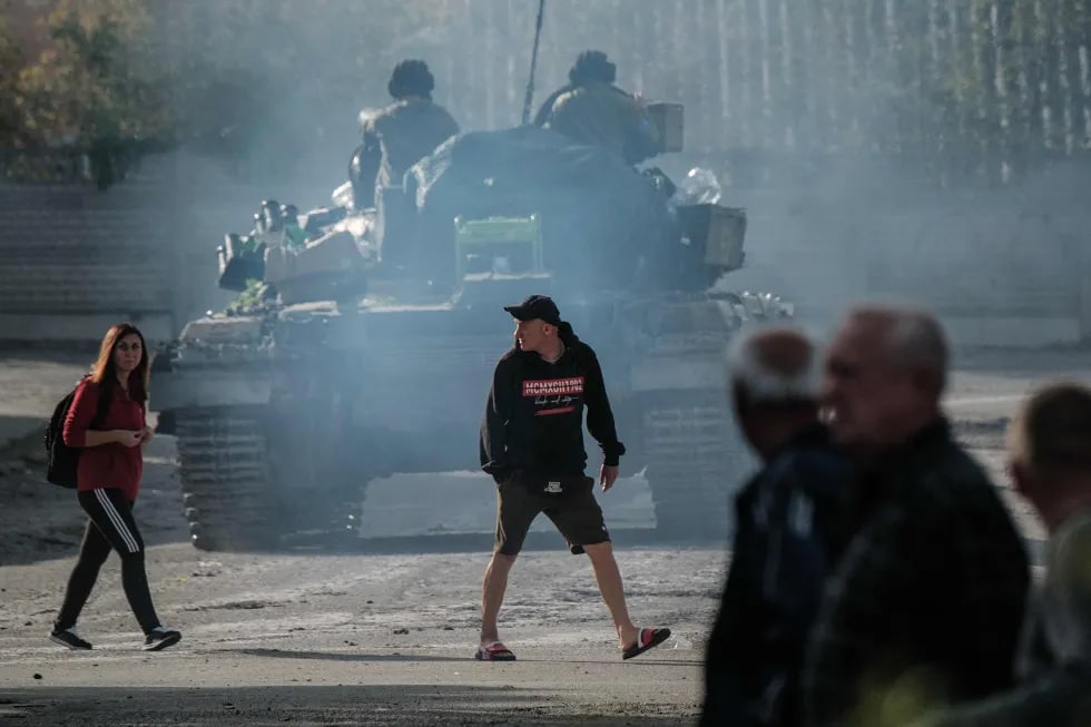 Kupyanskdagi Oskol daryosi yaqinida odamlar Ukraina tanki oldidan yo‘lni kesib o‘tmoqda.